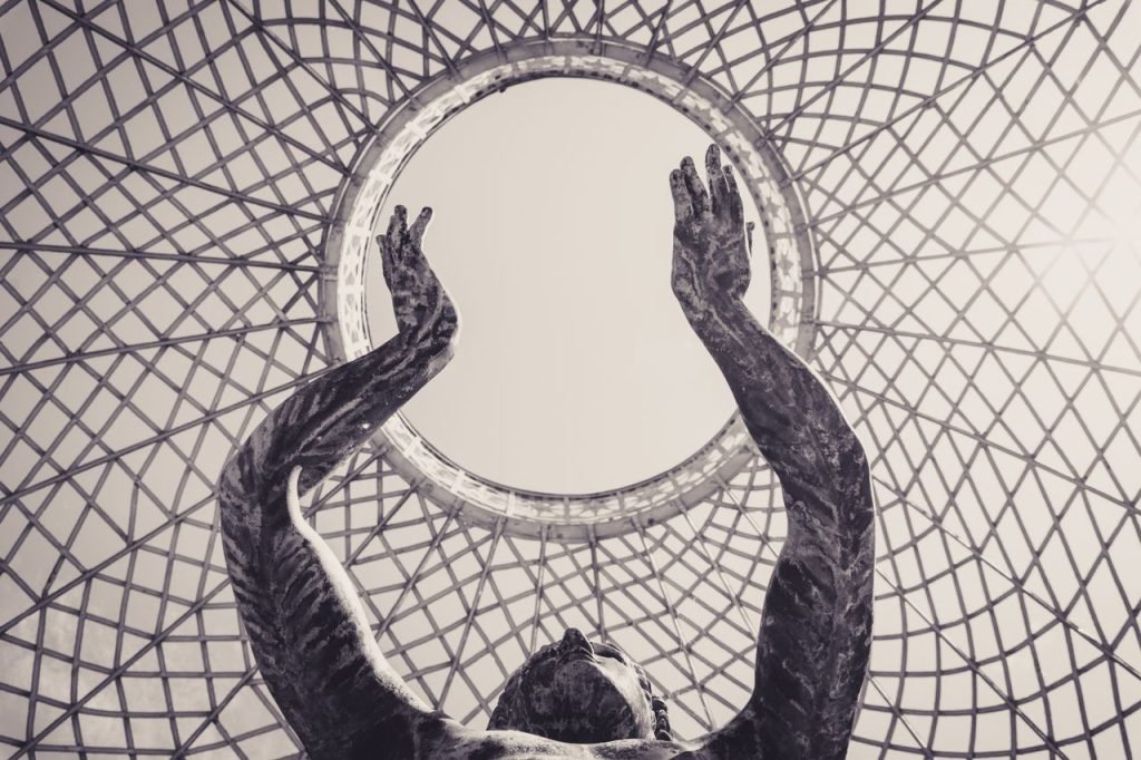 Dramatic sculpture reaching towards a circular sky framed by intricate lattice structure.